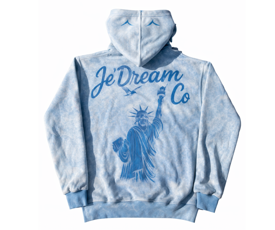 Light blue acid wash hoodie with 'Je'Dream Co' and Statue of Liberty design on a white background