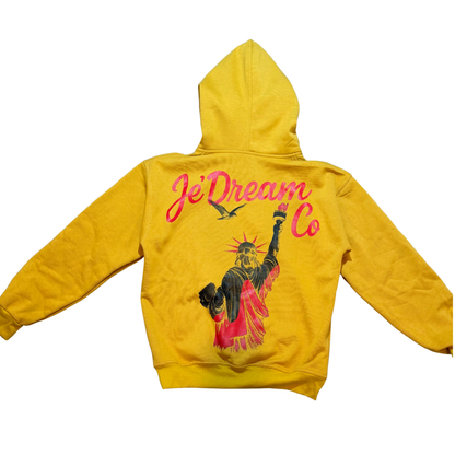 Yellow hoodie with 'JeDream Co' branding on the back and Statue of Liberty against a white background