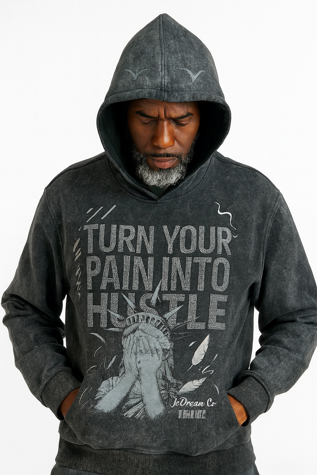 Man wearing a black acid wash hoodie with 'Turn Your Pain Into Hustle' text and graphic design.