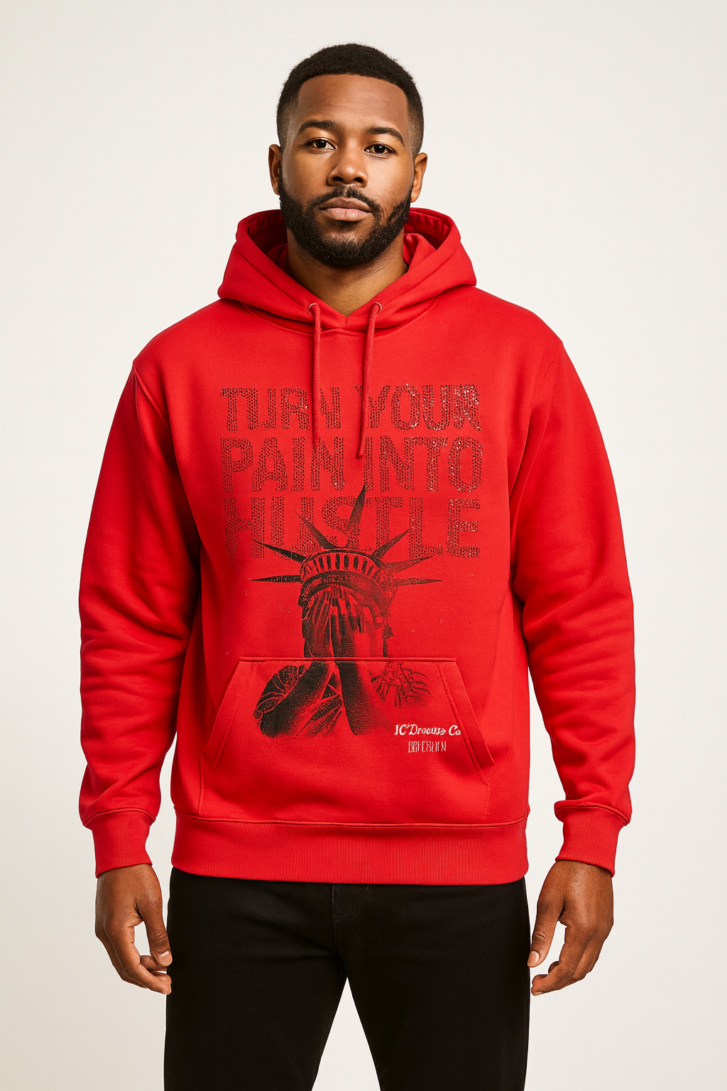 Man wearing a red hoodie with turn your pain into hustle in rhinestones and a graphic design on a white background
