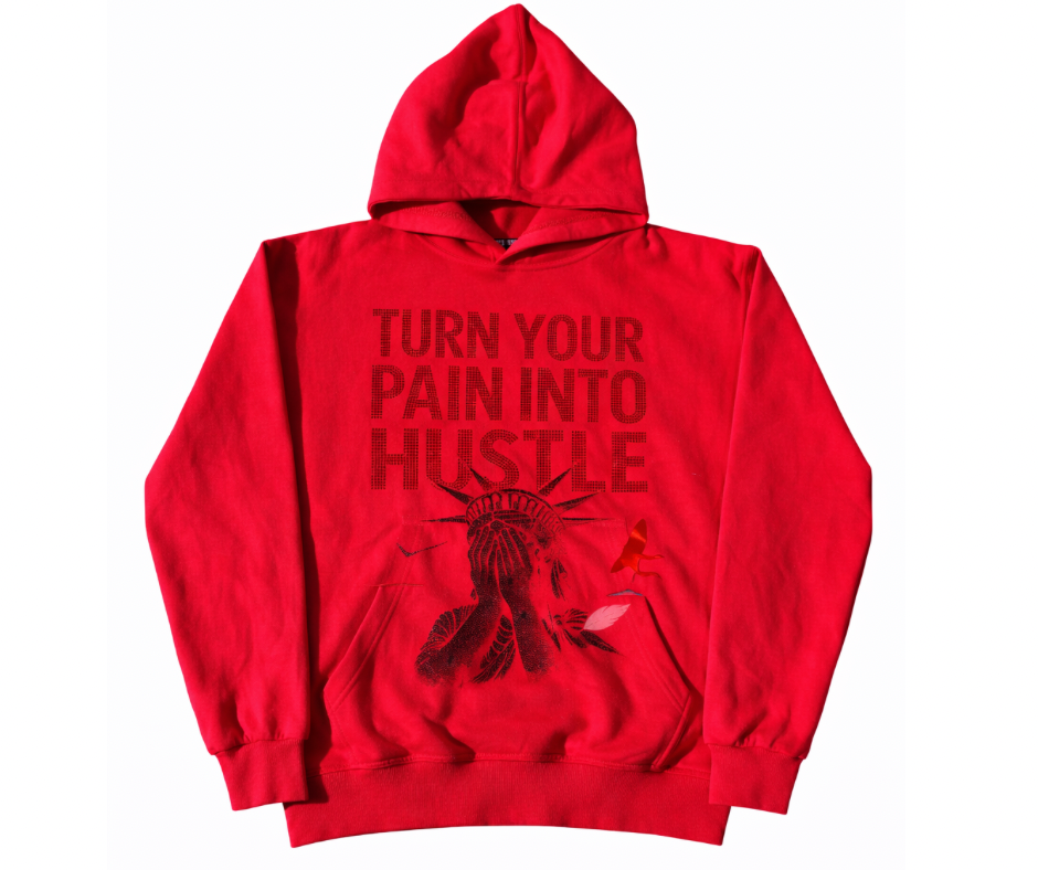Red hoodie with 'Turn Your Pain Into Hustle' text in rhinestones and a graphic of Statue of Liberty shame face 
