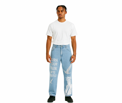 Person wearing our turn your pain into hustle light blue denim jeans with text and graphics birds symbol in rhinestone on a white background