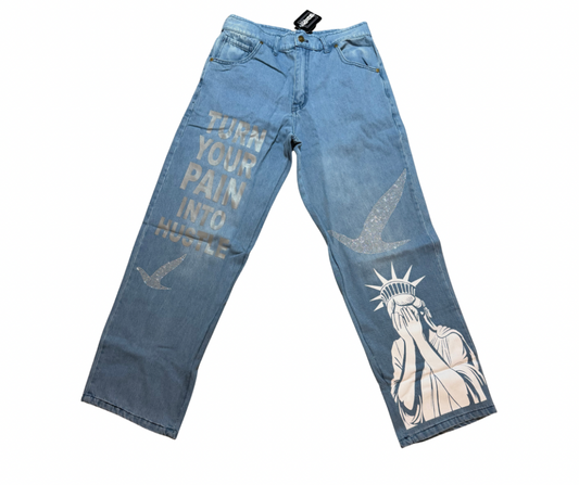 Turn your pain into hustle denim Blue jeans with artistic designs, 2 birds design in rhinestone and text on a white background